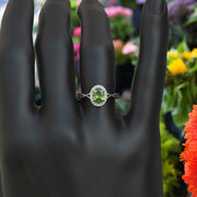 Green Oasis & Spiraled Elegance: Halo Ring Spotlighting Oval Peridot with Twisted Shank
